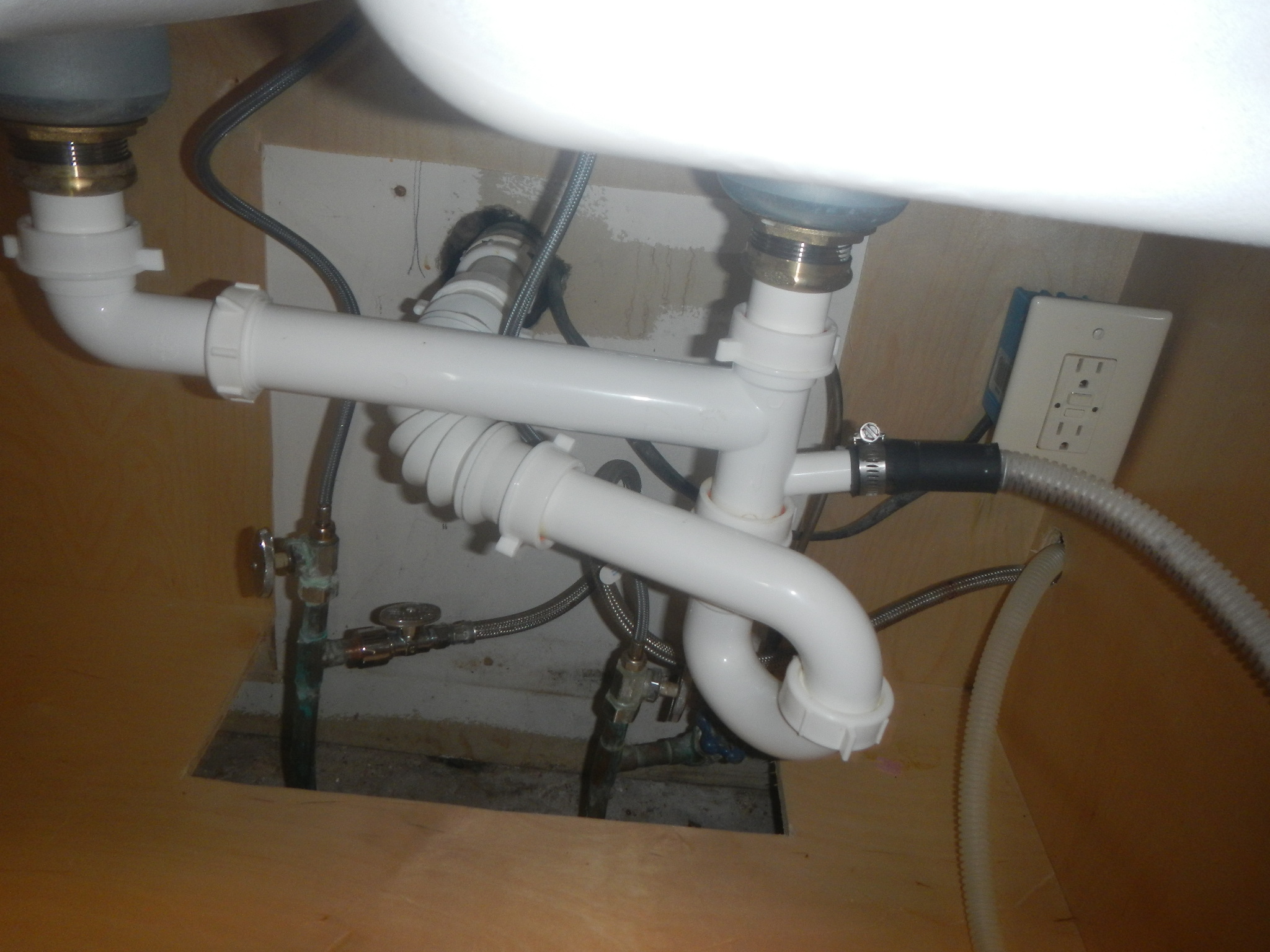 Handyman checking plumbing for leaks while performing home maintenance